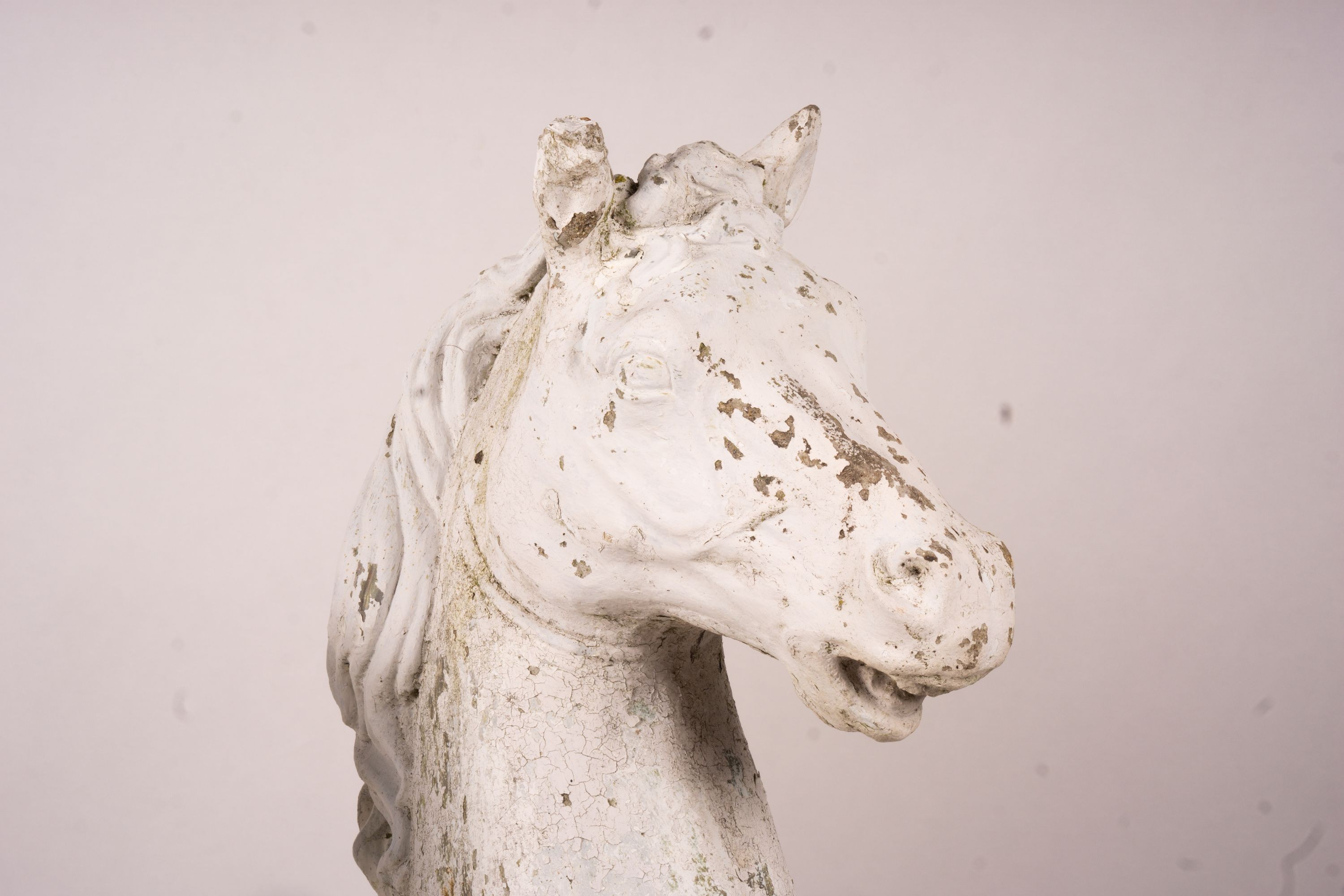 A pair of reconstituted stone horse's heads on plinth bases in the style of Austin and Seeley, height 104cm